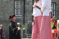 Town Crier looking up to stilt people